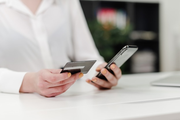 Woman using credit card and phone for payments | Premium Photo