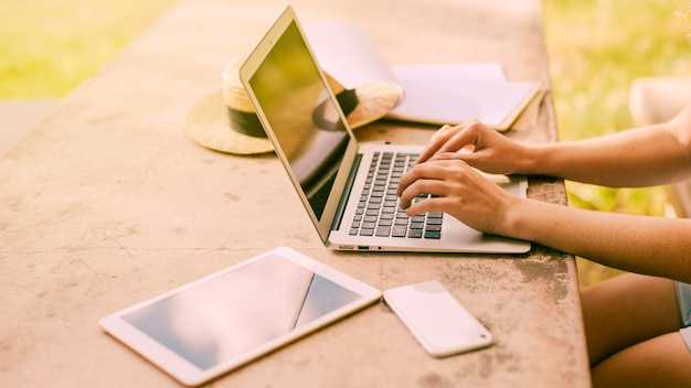 Woman using laptop at table outdoors Free Photo