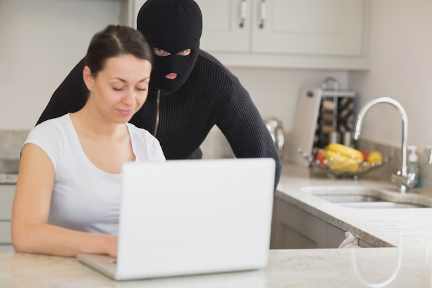 Woman Using Laptop While Burgler Is Watching Premium Photo