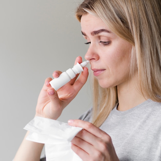 Woman using nasal spray Free Photo