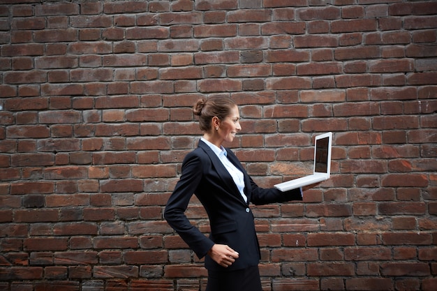 Woman walking with a laptop Free Photo