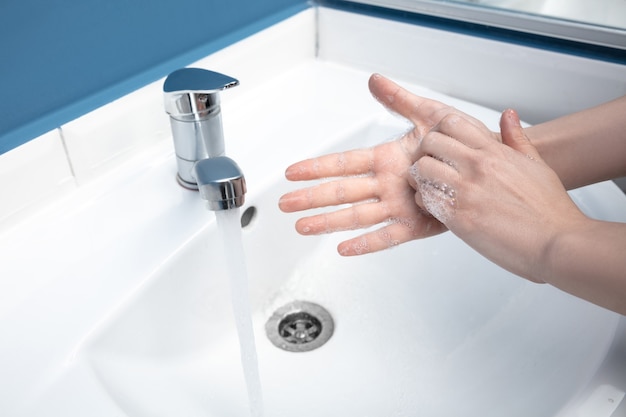 Premium Photo | Woman washing hands carefully with soap and sanitizer ...