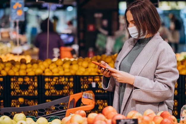 Woman wearing face mask and shopping in grocery store Free Photo