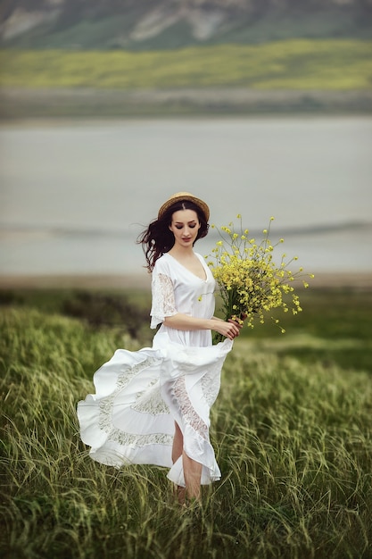 Premium Photo Woman In A White Dress Holding A Bouquet Of Flowers 