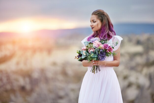 彼女の手に花の美しい花束を持つ女性が立っています プレミアム写真
