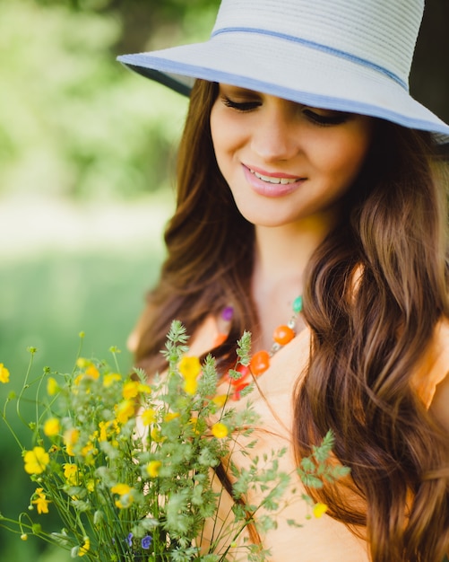 Woman with a hat holding flowers Photo | Premium Download