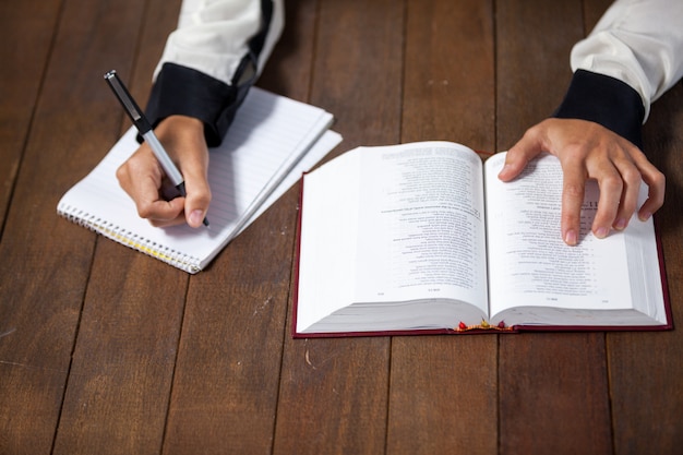 premium-photo-woman-with-a-bible-writing-on-notepad