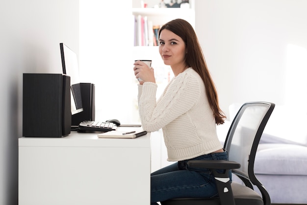 Free Photo | Woman with cup sitting at table