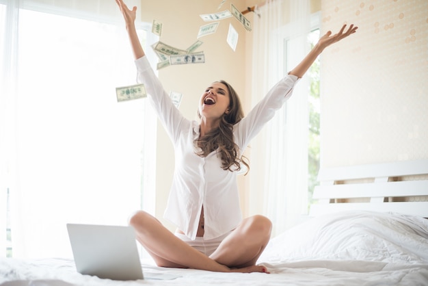 Woman with dollar bank note on the bed Free Photo