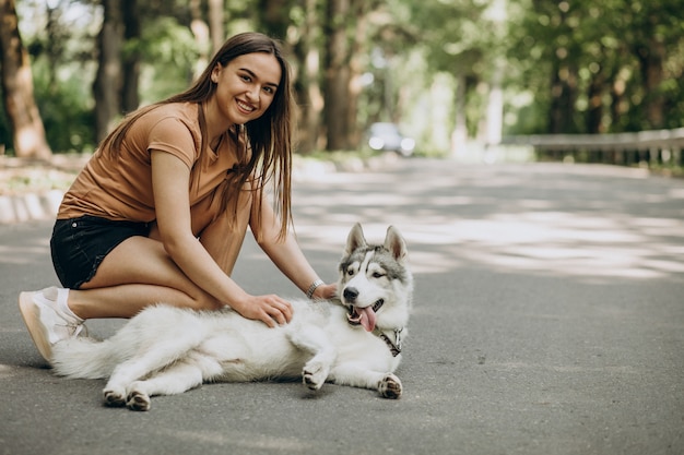 公園で彼女のハスキー犬を持つ女性 無料の写真