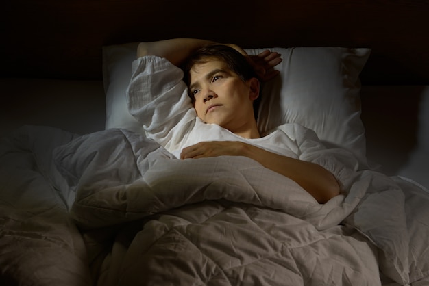 Woman with insomnia lying in bed with open eyes Premium Photo