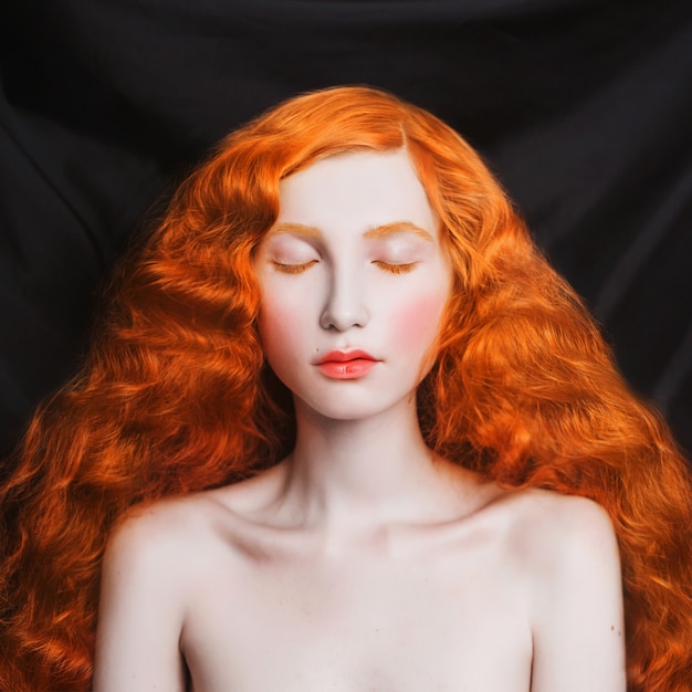 Woman With Long Curly Red Flowing Hair On A Black Bac