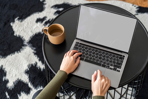 Woman working from home on a laptop with empty screen Free Photo