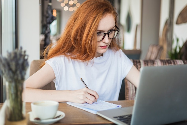 Woman working on laptop at table Free Photo Woman working on laptop at table Free Photo