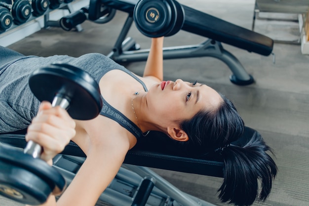 Woman Workout For Dumbbell Bench Press In The Fitness Gym