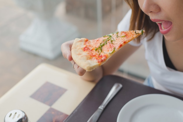 Women eating a delicious margarita pizza in restaurant. Premium Photo