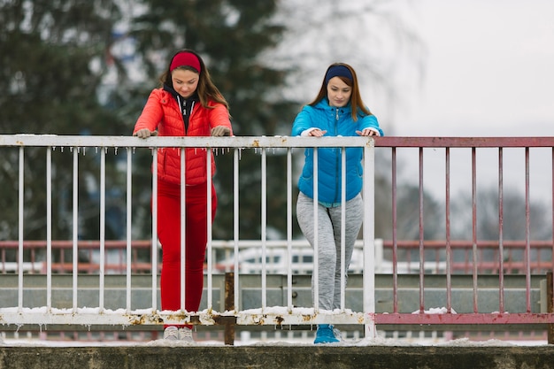 橋の手すりの近くで運動する女性 無料の写真