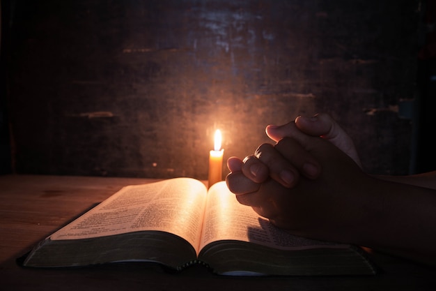 Free Photo | Women praying on the bible in the light candles selective ...