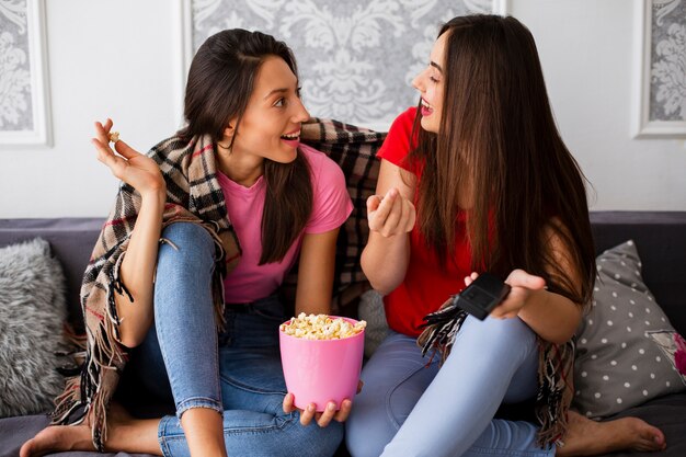 Women Relaxing At Home And Eating Popcorn Free Photo