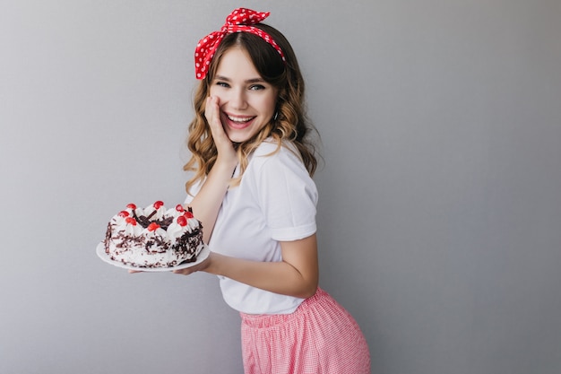 ポジティブな誠実な感情を表現する素晴らしい誕生日の女の子 甘いケーキでポーズをとるヴィンテージの衣装でうれしいヨーロッパの女性の屋内ショット 無料の写真