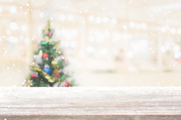 Download Premium Photo Wood Table Top On Blur With Bokeh Christmas Tree Background With Snowfall PSD Mockup Templates