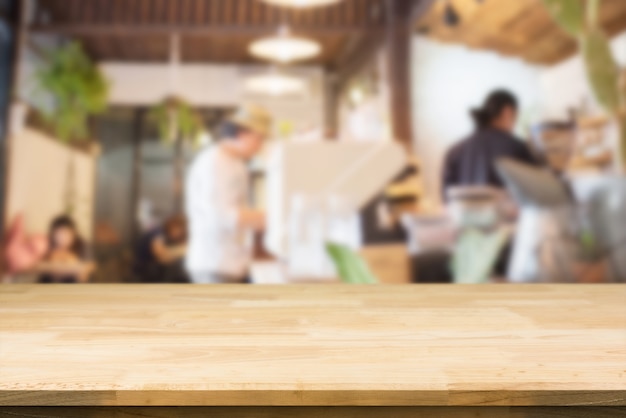 ぼかしカフェのインテリアの背景に木製テーブルトップ プレミアム写真