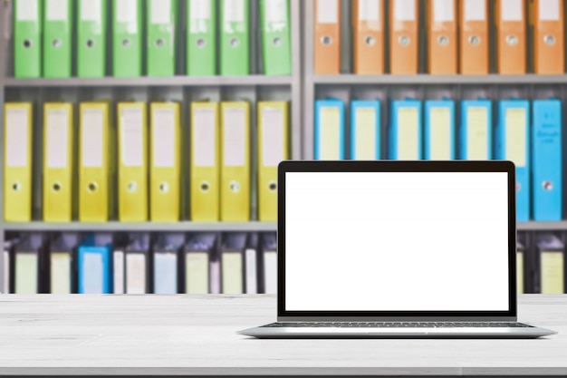 Wood table top with notebook on blurred office document folders standing in a row of on document storage for background Premium Photo