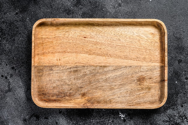 Wooden antique tray. black texturized background. top view. copy space