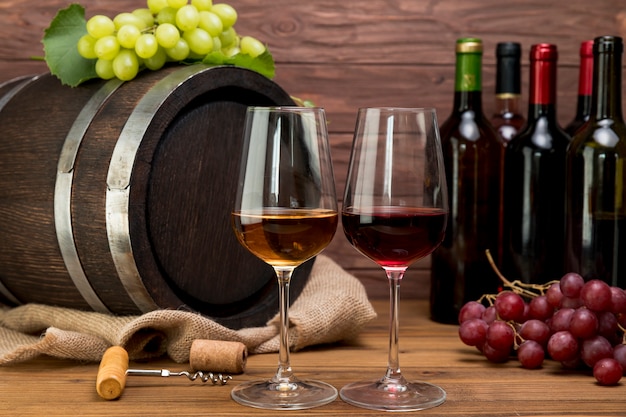 Premium Photo | Wooden barrel with bottles and glasses of wine