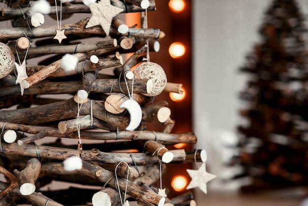 手作りのおもちゃで木製の装飾クリスマスツリー 素朴なスタイルで装飾されたスタイリッシュなクリスマスインテリア プレミアム写真