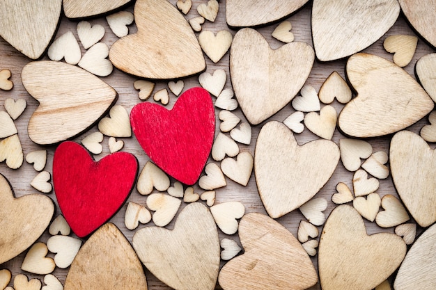 Premium Photo | Wooden hearts, one red heart on the heart background.