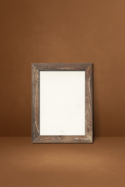 Premium Photo | Wooden picture frame leaning on a brown wall. blank ...