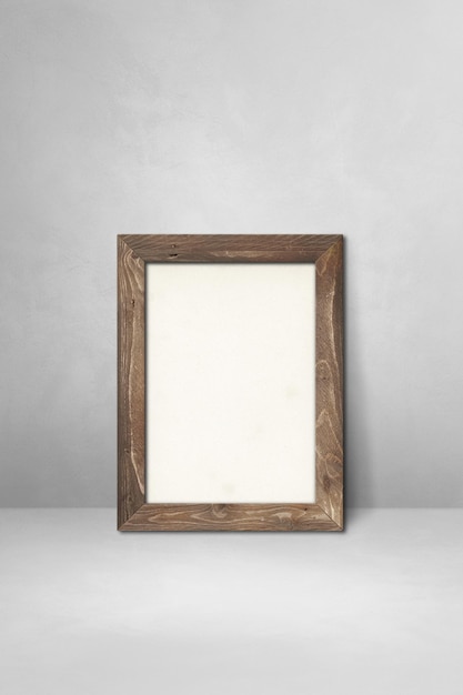 Premium Photo | Wooden picture frame leaning on a light grey wall ...