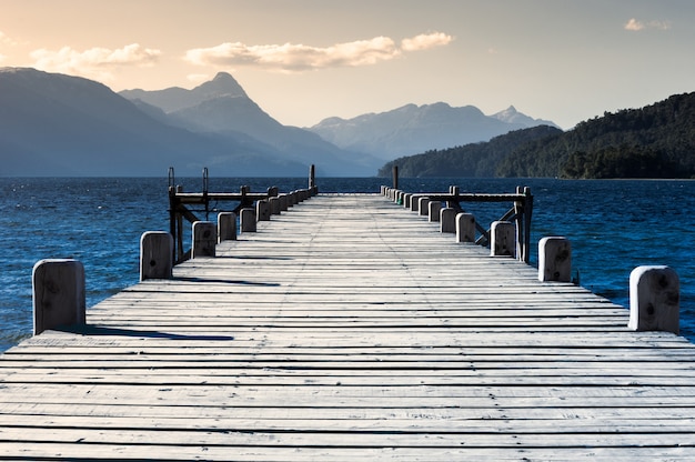 Premium Photo | Wooden pier on a lake with mountains in the background