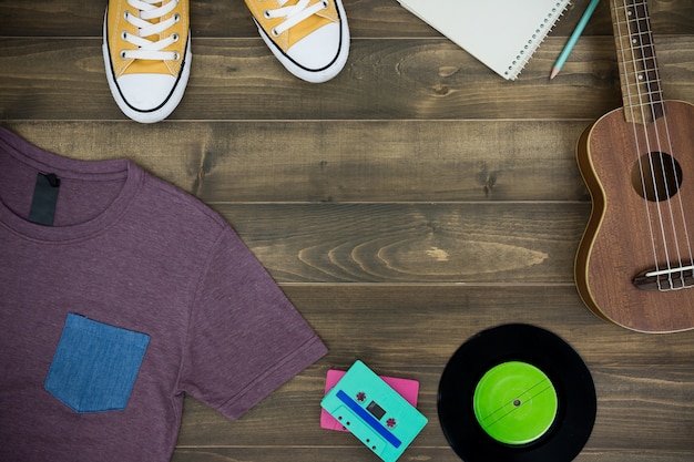 Wooden table of music composer, ukulele, notebook, audio cassettes, tape recorder and clothes Premium Photo