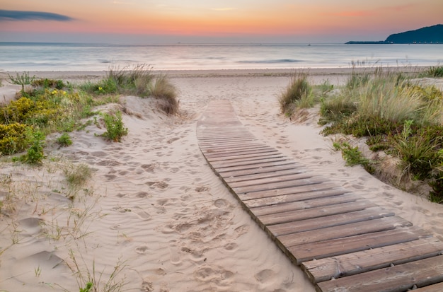 Wooden walkway entering the beach at sunrise | Premium Photo