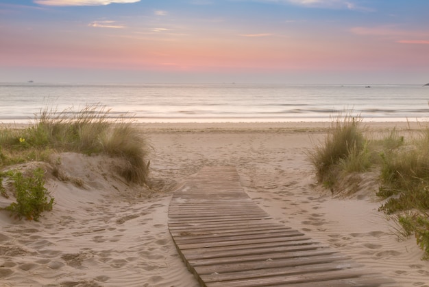 Premium Photo | Wooden walkway entering the beach at sunrise