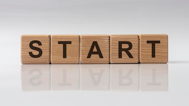 Premium Photo | Word start made with wooden cubes, white background ...