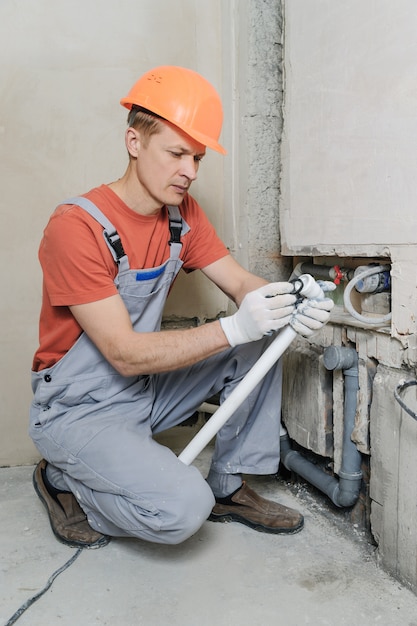 Premium Photo | Worker is installing sewer pipes.