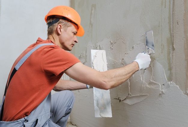 Premium Photo | Worker is putting a gypsum plaste.