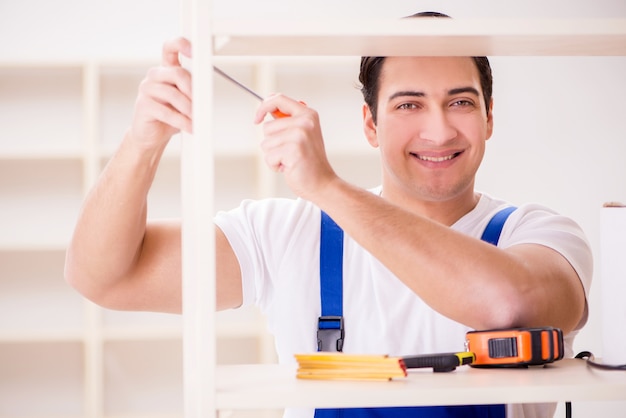 Worker man repairing assembling bookshelf Premium Photo