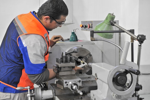 Premium Photo | Worker in the process details of machining on a lathe ...