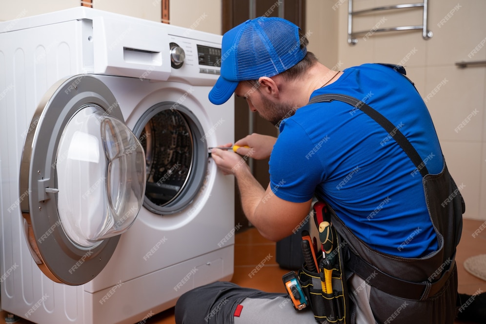 premium-photo-working-man-plumber-repairs-a-washing-machine-in-home