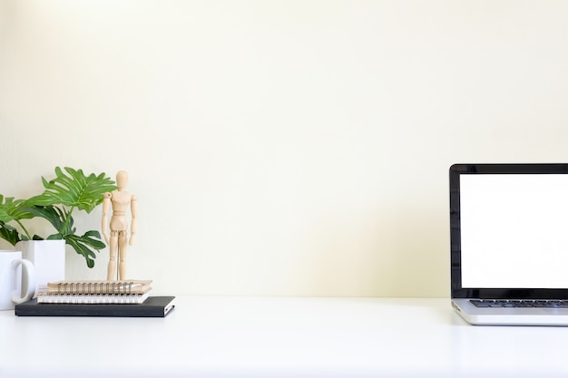 Premium Photo | Workspace with laptop computer on white table and ...