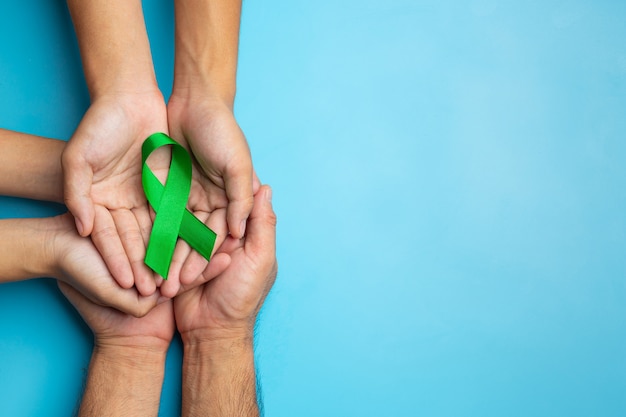 Free Photo World Mental Health Day Green Ribbon Put In Humans Hands On Blue Background 6434