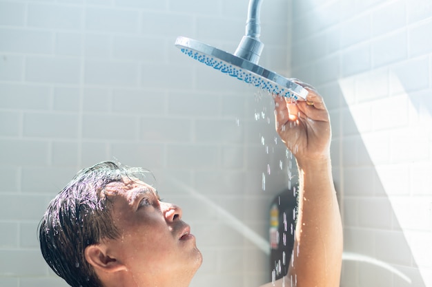 Worried Asian Man Takes A Shower Premium Photo