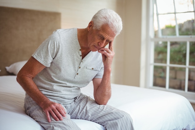 Premium Photo Worried Senior Man Sitting On Bed