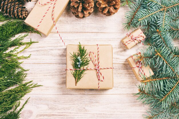 Premium Photo | Wrapping christmas gift with fir tree and pine cone ...