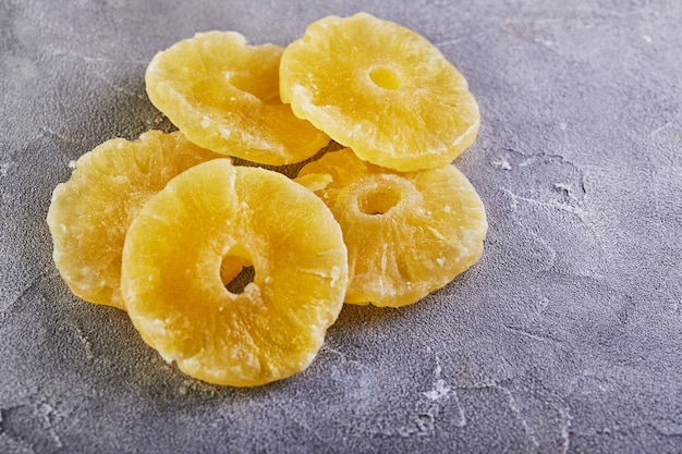 Premium Photo | Yellow candied pineapple rings on a gray concrete table ...