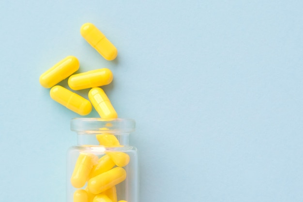 Download Premium Photo Yellow Capsules From Glass Bottle On Blue PSD Mockup Templates